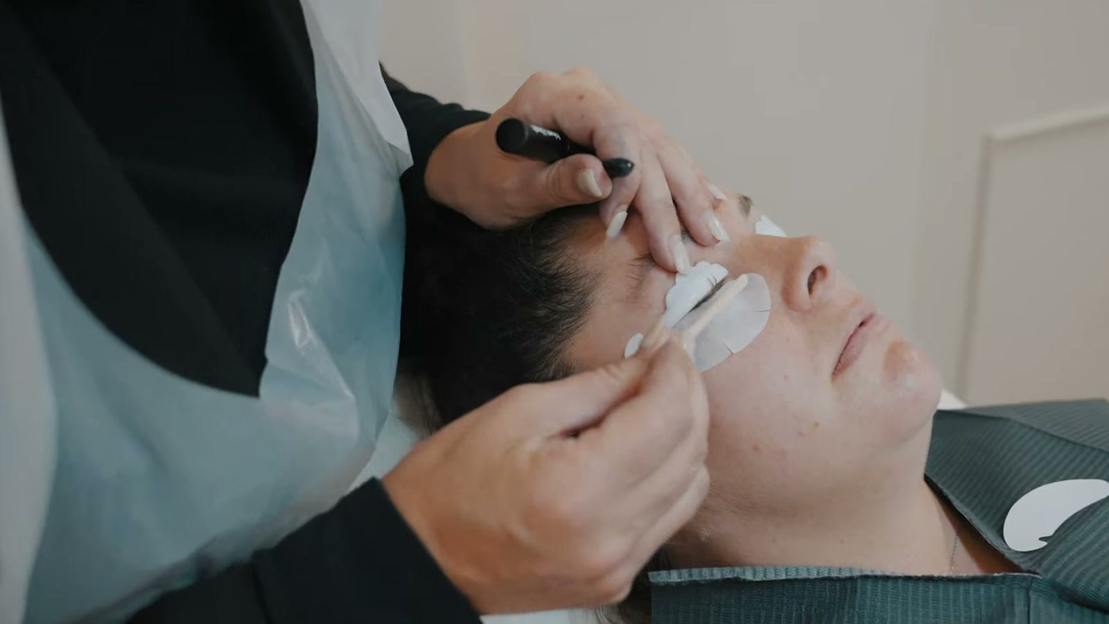 A lash treatment being applied to a client lying back on a couch at RJL Education in Bolton