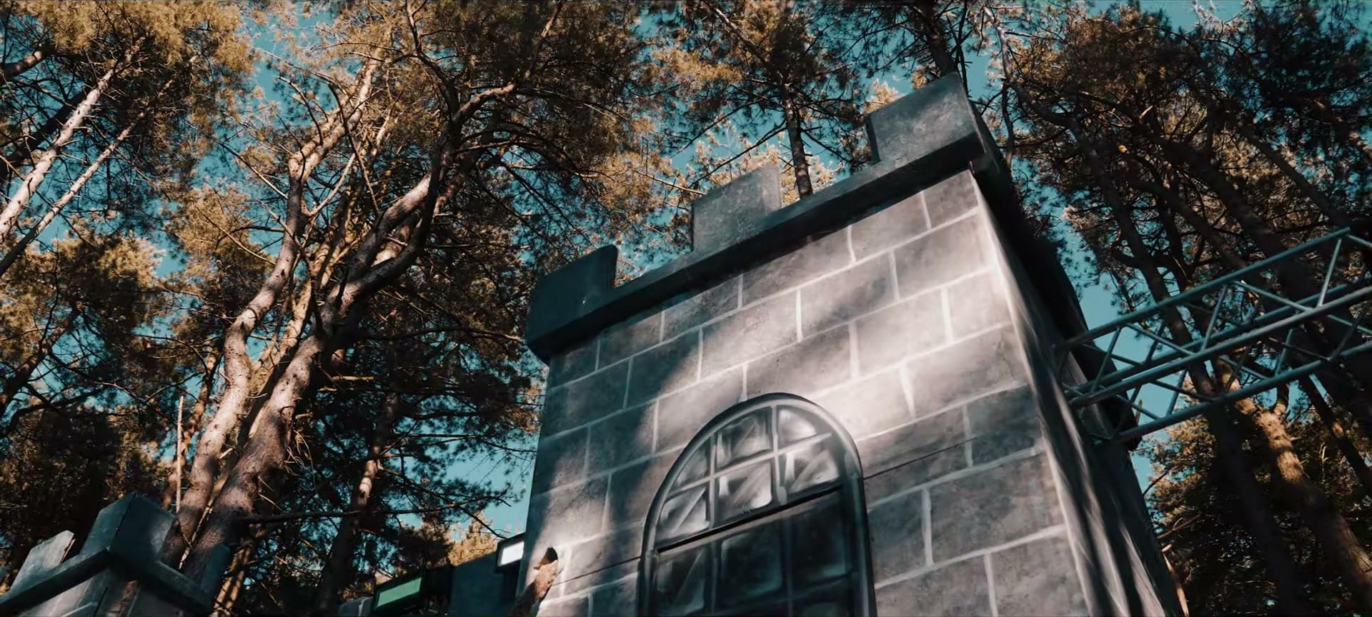 A castle-style stage set among tall pine trees at Restricted Forest