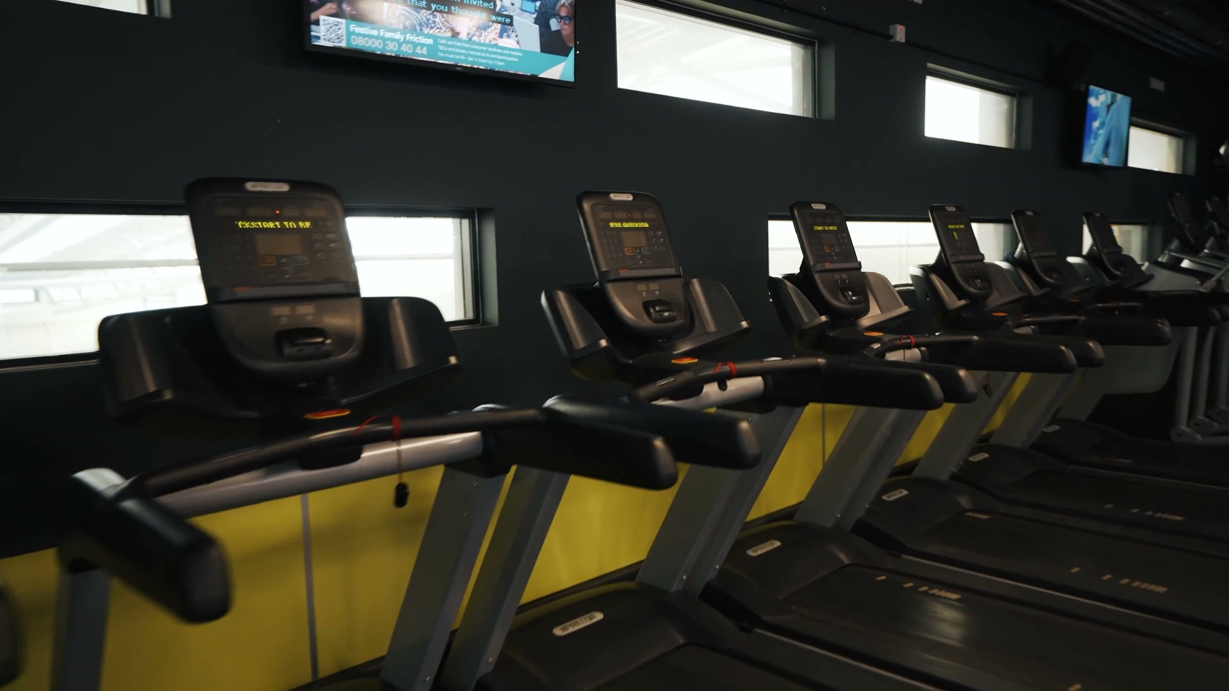 A row of treadmills facing the windows in a BwD Leisure gym