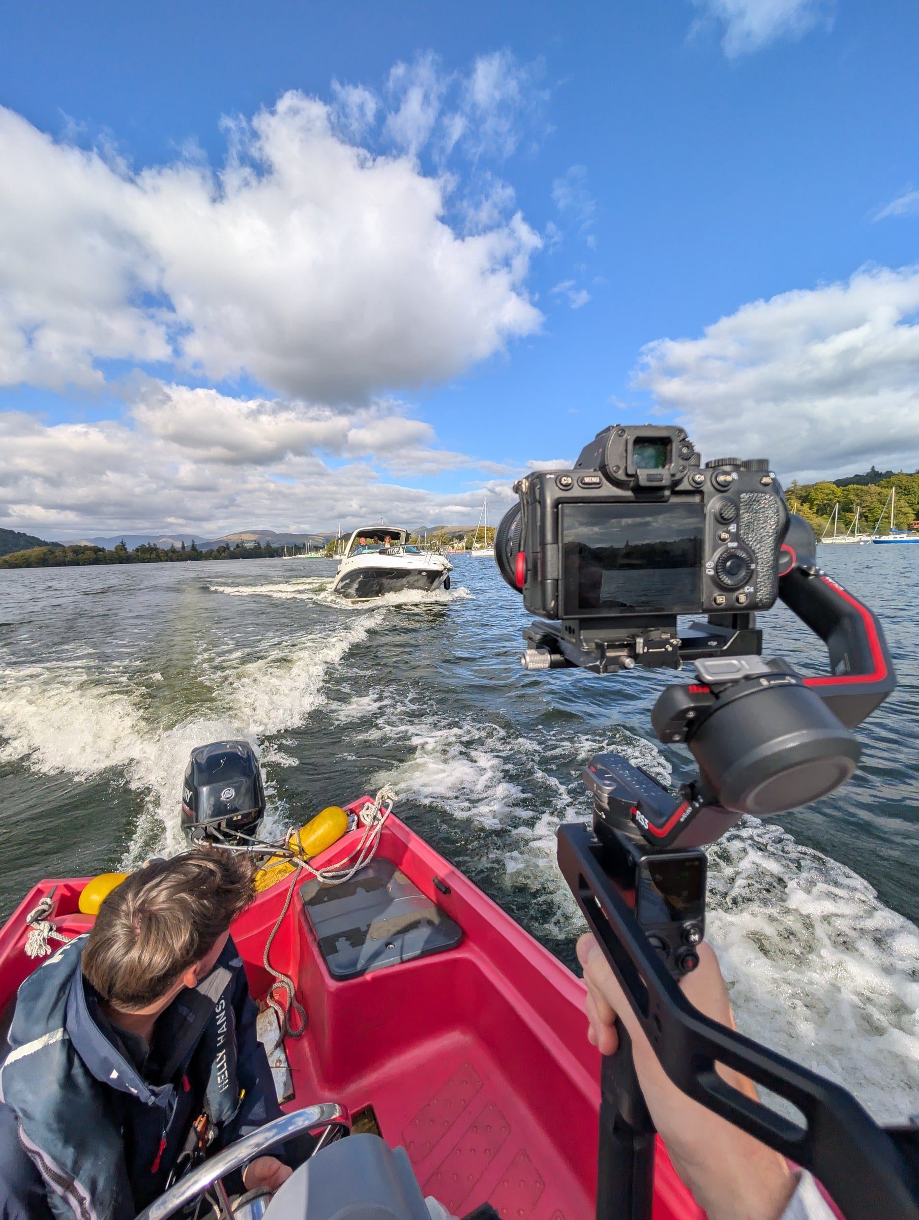 Filming from the back of a speedboat on open water, camera rig in the foreground