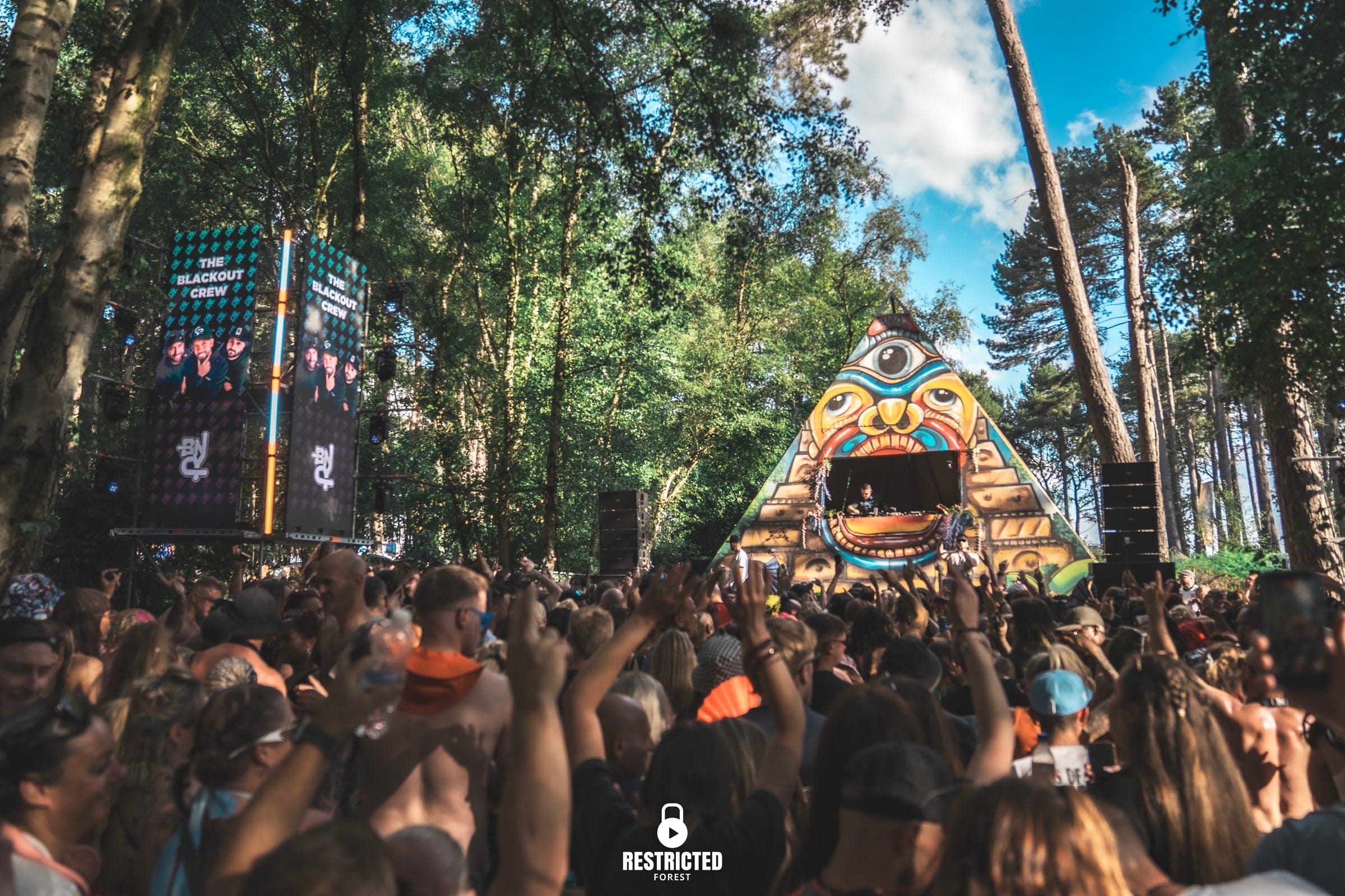 The BNCY Pyramid Stage wide, LED towers either side and the crowd hands up in daylight
