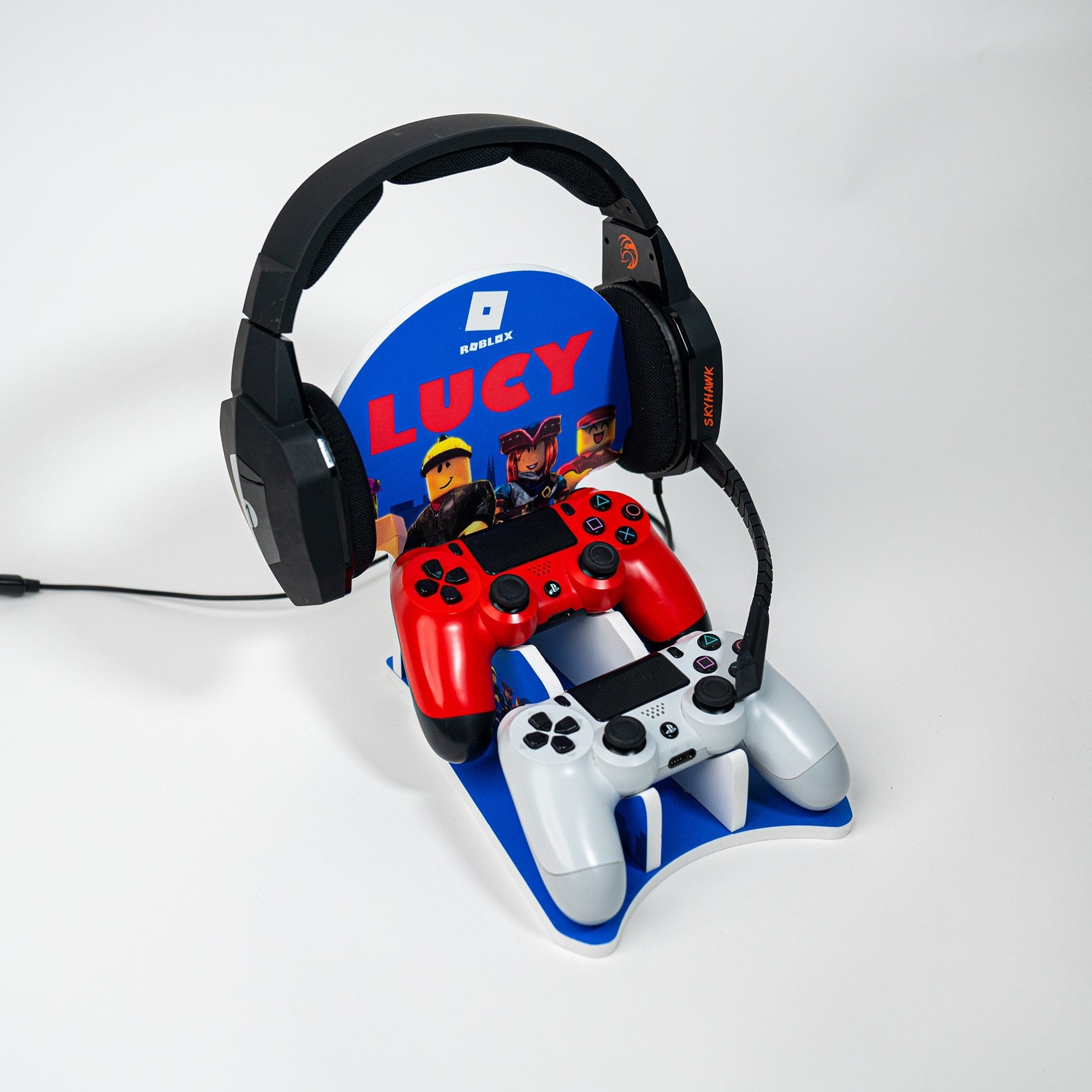 A gaming headset and a red controller on a personalised display stand, shot on white