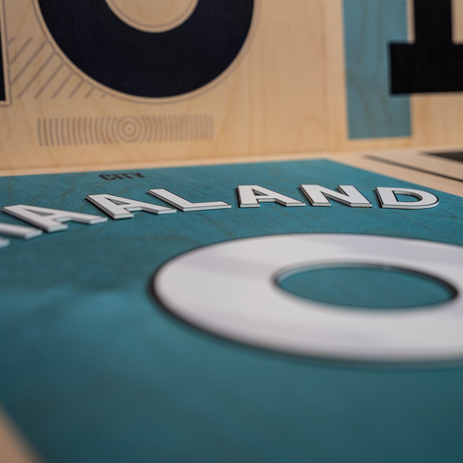 Close detail of a teal and white football shirt name print on a wooden frame