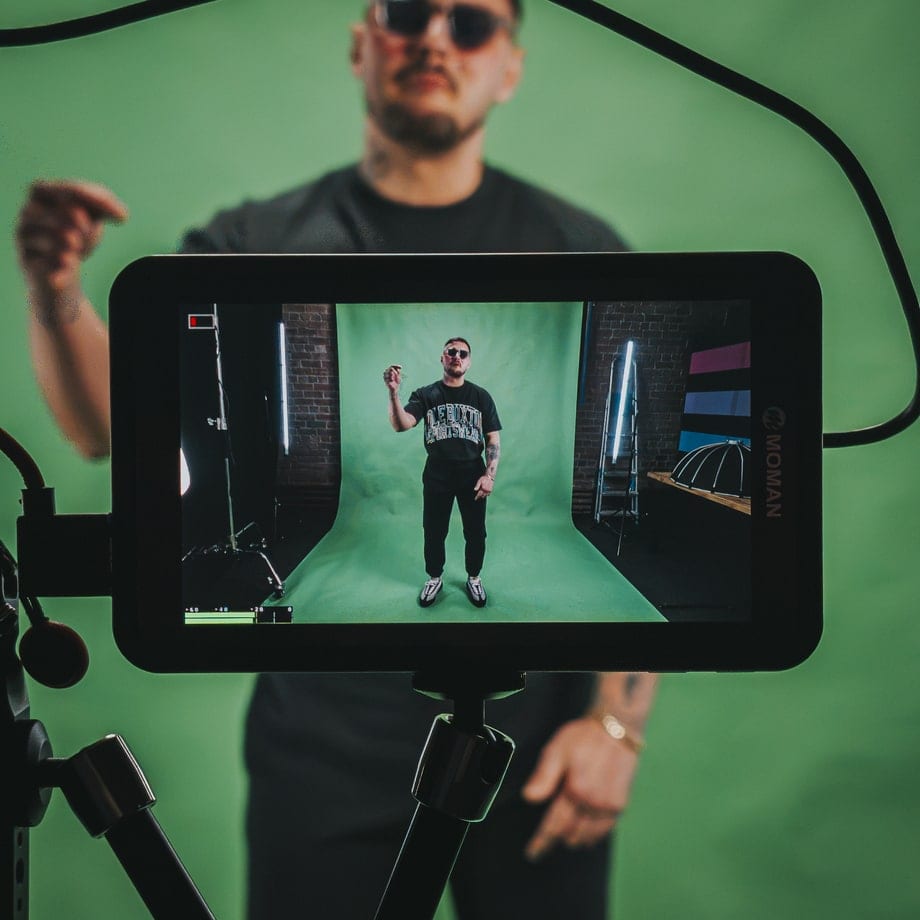 A performer on the green screen cyclorama, framed on the camera monitor